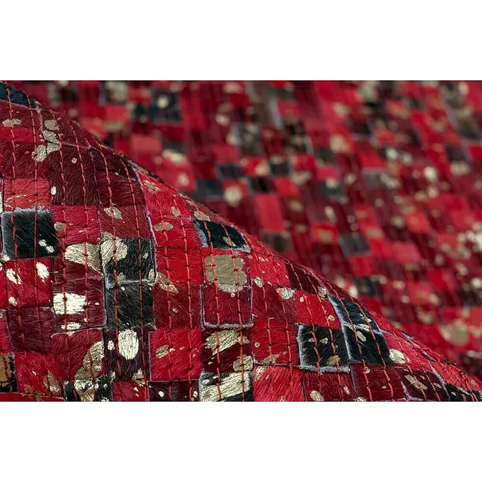 Kayoom Lederteppich Finish - Rot, 230 x 160 cm, 100 % Leder - Nahaufnahme eines rot-schwarzen Teppichs mit goldenen Akzenten, der eine elegante und luxuriöse Atmosphäre ausstrahlt.