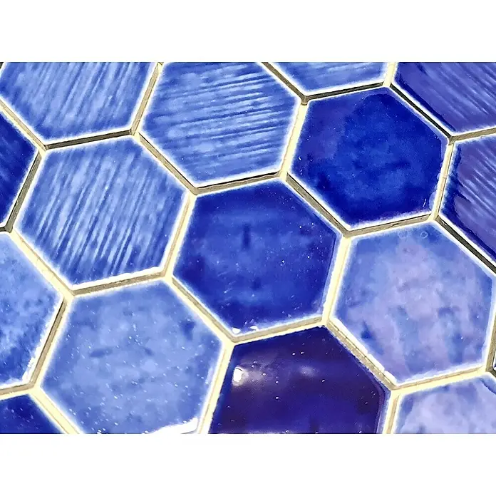 Mosaikfliese Hexagon CG SAN7 - Blau, Glänzend, L x B x S: 25,3 cm x 29,3 cm x 7 mm - Nahaufnahme von blau gefärbten Sechseckfliesen mit cremefarbenen Fugen, die ein geometrisches Muster für Badezimmer oder Küchenrückwände bilden.
