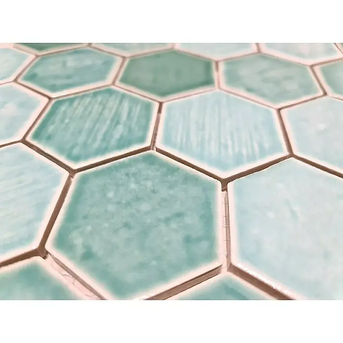 Mosaikfliese Hexagon CG SAN5 - Grün, Glänzend, L x B x S: 25,3 cm x 29,3 cm x 7 mm - Nahaufnahme von türkisfarbenen Sechseckfliesen mit einer leicht unebenen Oberfläche und hellen Fugen, die ein interessantes Muster bilden.