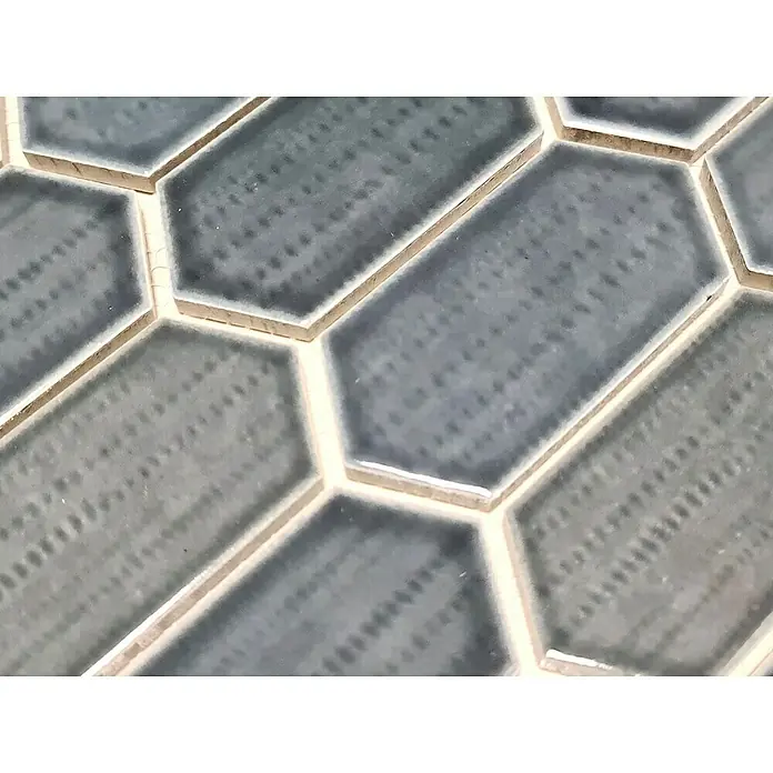 Mosaikfliese Hexagon CG CH479 - Schwarz, Glänzend, 25,3 cm x 29,3 cm x 75 mm - Nahaufnahme von grauen, länglichen Sechseckfliesen mit hellen Fugenlinien, die ein modernes und stilvolles Design zeigen.