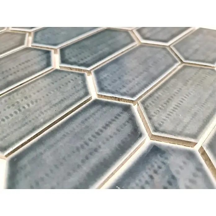 Mosaikfliese Hexagon CG CH479 - Schwarz, Glänzend, 25,3 cm x 29,3 cm x 75 mm - Nahaufnahme von blauen, länglichen Sechseckfliesen mit einem subtilen Punktmuster, die ein modernes und stilvolles Designelement darstellen.