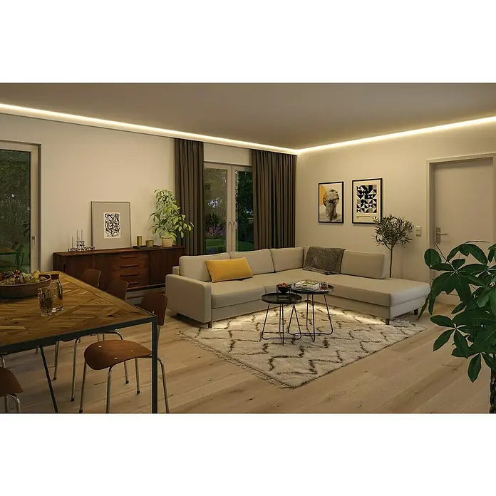 Paulmann MaxLED 1.000 LED-Band Stripe - 250 cm, RGBW, 28 W, 2.500 lm, 230 V - 240 V - Einladendes Wohnzimmer mit einem grauen Ecksofa, einem dekorativen Teppich und stimmungsvoller indirekter Beleuchtung. Die warmen Holztöne und die Pflanzen sorgen für Behaglichkeit.