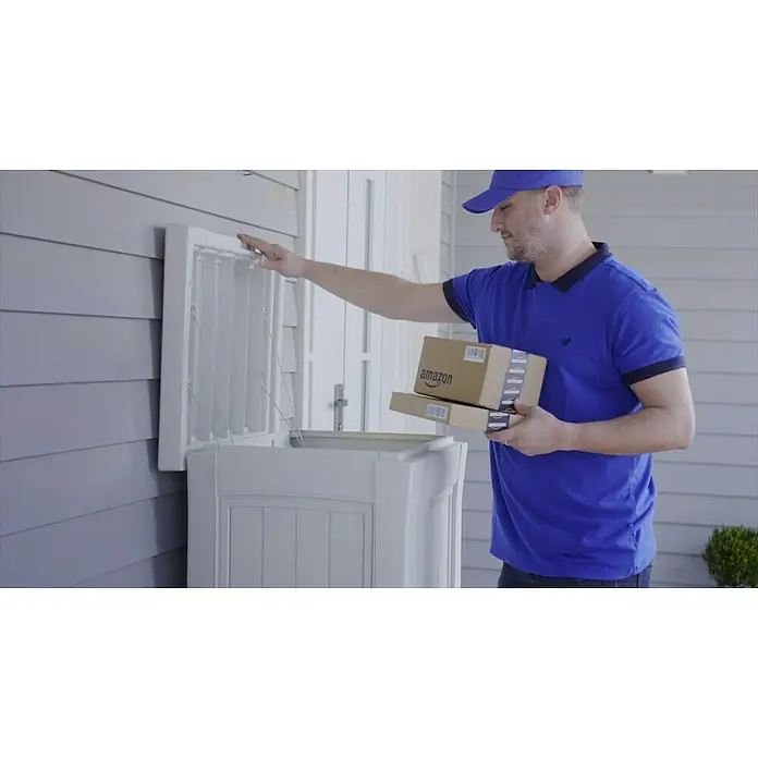 Keter Garten-Aufbewahrungsbox Paketbox ParcelDropBox - 62,1 x 62,1 x 112 cm, Grau - Ein Amazon-Lieferant legt Pakete in einen Paketkasten an einem Haus. Praktische und sichere Zustellung von Online-Bestellungen.