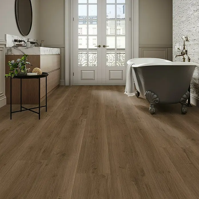 Parador Designboden Modular One - Eiche Spirit Geräuchert, Landhausdiele, 2.200 x 235 x 8 mm - Blick in ein Badezimmer mit Holzboden, Badewanne und Waschbecken. Das warme Holz harmoniert mit dem klassischen Design.