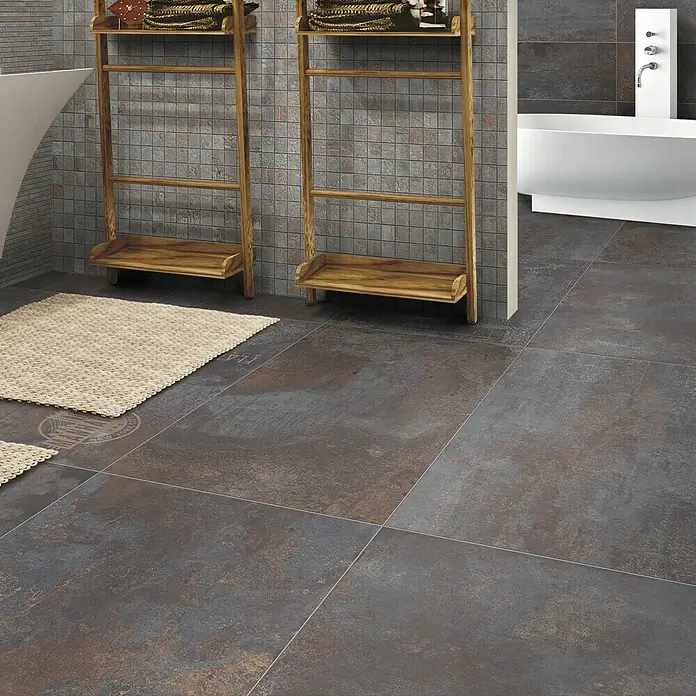 Feinsteinzeugfliese Flatiron - 60 x 120 cm, Silber, Matt - Ein Badezimmer mit dunklen Bodenfliesen, zwei Holzleitern mit Handtüchern und einer freistehenden Badewanne für ein modernes Design.