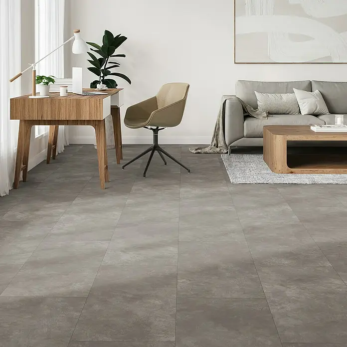 Parador Designboden Modular One - Beton dunkelgrau, Fliese, 853 x 400 x 8 mm - Ansicht eines grauen Bodens mit Möbeln. Der Boden besteht aus großen grauen Fliesen und sorgt für eine elegante, moderne Optik.