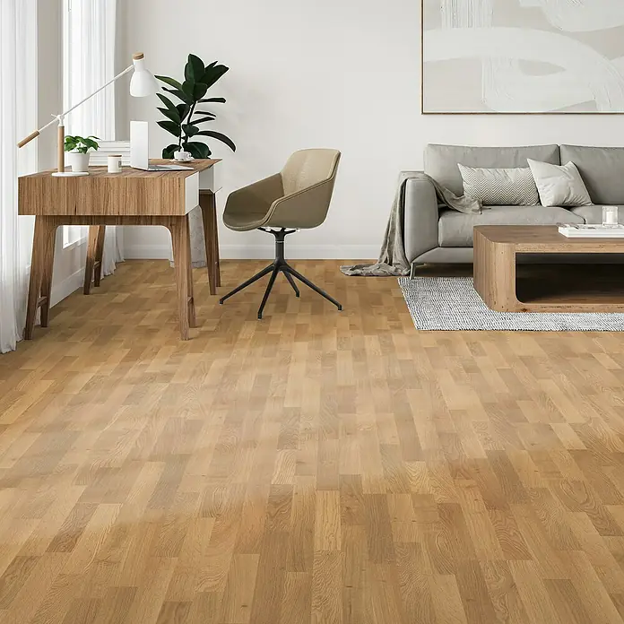 Parador Laminat Basic 400 - Eiche natur, Schiffsboden, 1.285 x 194 x 8 mm - Ein heller Büroraum mit einem Schreibtisch aus Holz, einem Stuhl, einem Sofa und einem Teppich. Das Parkett ist auffällig.