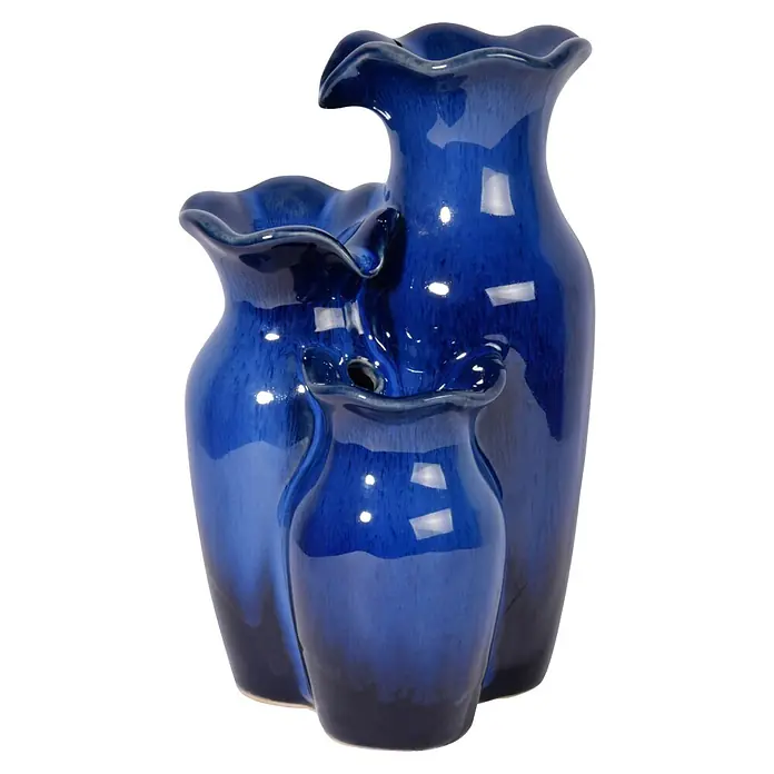 Dobar Zimmerbrunnen - L x B x H: 14 x 12,5 x 22 cm - Drei blaue, dekorative Keramikvasen mit wellenförmigen Öffnungen, die sich in Größe und Farbton unterscheiden, vor einem schwarzen Hintergrund.