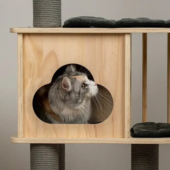 Dobar Kratzbaum Mila - 68 x 48 x 116 cm, Holz, Natur/ Grau - Katzenhaus mit Aussicht: Eine Katze blickt aus einem Holzhaus mit einem einzigartigen Kleeblatt-förmigen Eingang.