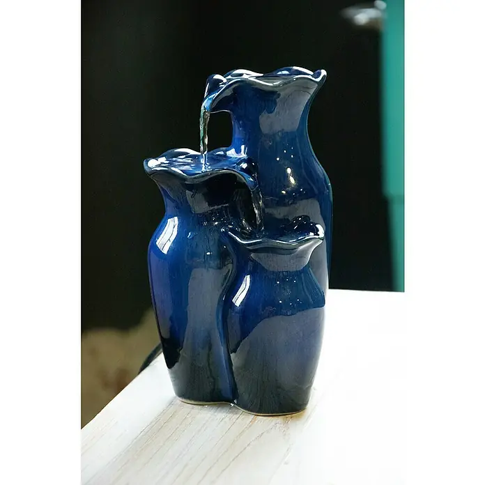 Dobar Zimmerbrunnen - L x B x H: 14 x 12,5 x 22 cm - Eine blaue Zimmerbrunnen-Skulptur mit drei Vasen, aus denen Wasser fließt, steht auf einem Tisch. Die elegante Dekoration sorgt für Entspannung.