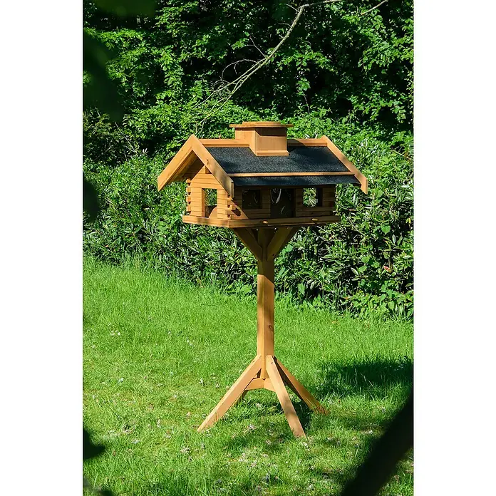 Dobar Vogelfutterhaus - 84 x 78 x 110 cm, Braun, Holz - Ein hölzernes Vogelhaus auf einem Ständer inmitten eines grünen Gartens, ideal um Vögel anzulocken und das Gartenerlebnis zu bereichern.