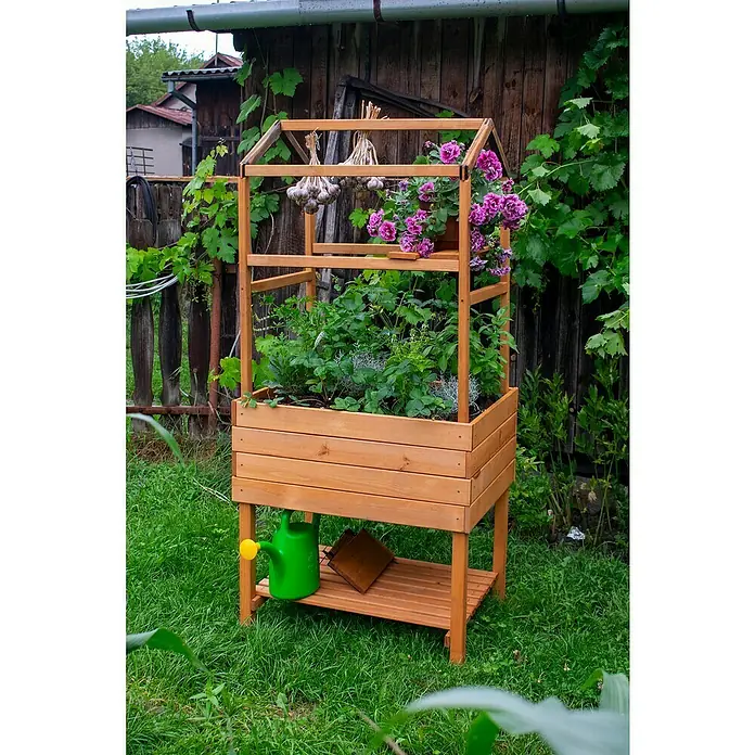 Dobar Pflanzturm - 75 x 54 x 91,5 cm, Braun - Ein hölzernes Hochbeet mit mehreren Ebenen, bepflanzt mit Blumen und Kräutern, und darunter eine grüne Gießkanne.