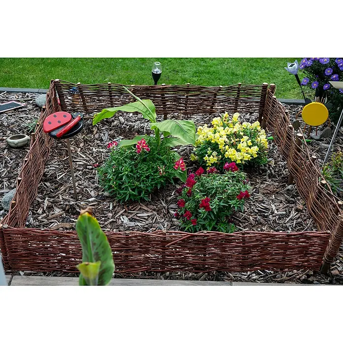 Dobar Beeteinfassung 4er Set - 100 x 20 cm, Weide - Bezaubernder Garten mit Blumenbeet, umrandet von einem dekorativen Weidenzaun, der rustikalen Charme und natürliche Schönheit vereint.