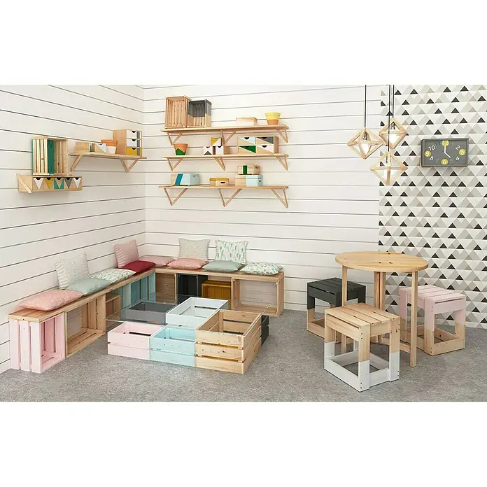 Astigarraga Triangle Soporte de estanterías - L x Al: 20 x 20 cm, Carga soportada: 20 kg, Natural - Esta imagen muestra un área de juegos para niños con estanterías, bancos y una mesa, todo hecho con cajas de madera clara y toques de color.