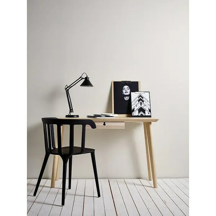 A.S. Création Vliestapete Glatte Wand Meistervlies 5 - Beige/Creme, Uni, 10,05 x 0,53 m - Schreibtisch mit Lampe und Stuhl. Der helle Holzschreibtisch bietet eine Arbeitsfläche mit Schublade, Lampe, Notizbüchern und Bildern im Hintergrund.