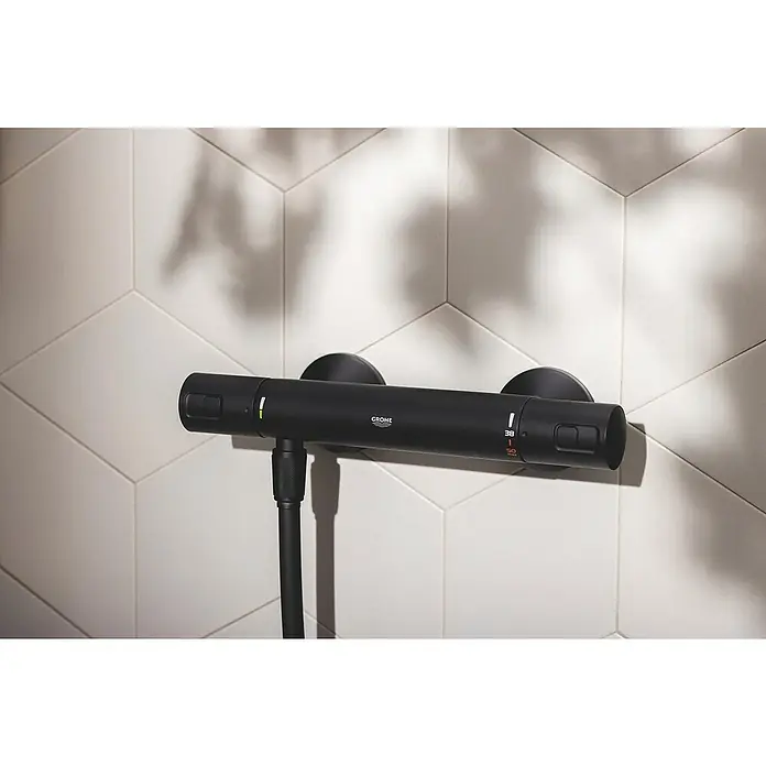 Grohe Start Brausethermostat Precision - Matt, Schwarz - Nahaufnahme des Grohe Thermostat-Duschsystems vor weißem, geometrischem Hintergrund, das modernes Design und Funktionalität vereint.