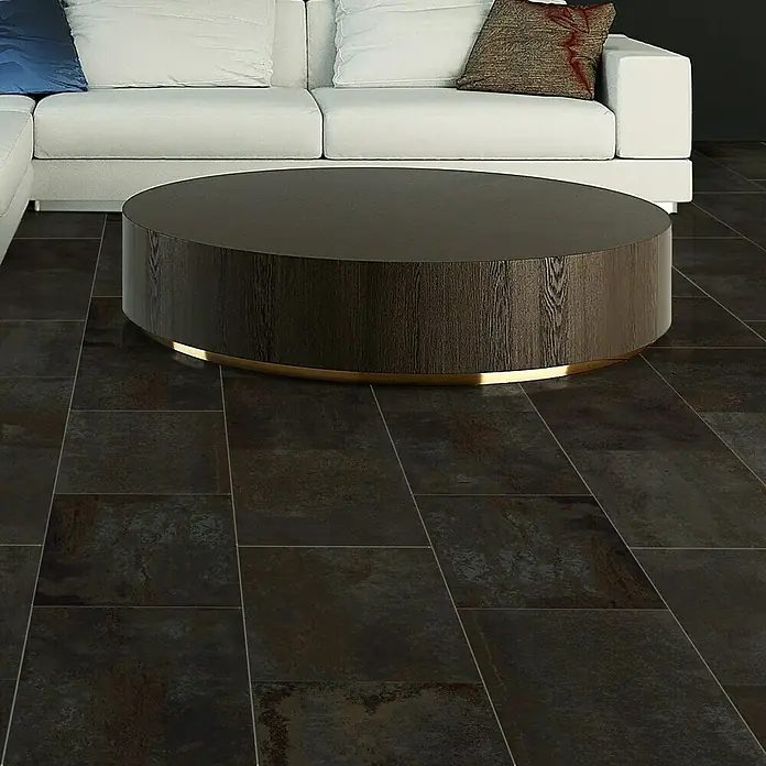 Feinsteinzeugfliese Flatiron - 60 x 120 cm, Schwarz, Matt - Elegantes Wohnzimmer mit einem runden Couchtisch aus dunklem Holz mit goldener Basis auf dunklem Steinboden vor einem weißen Sofa.