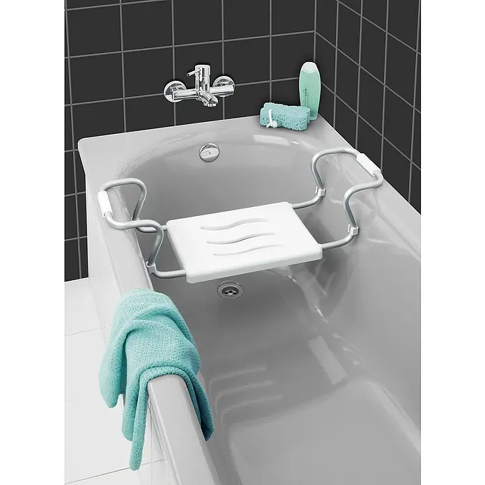Wenko Badewannensitz Secura - Belastbarkeit: 120 kg - Ein Badezimmer mit einer Badewanne, einem Badesitz mit Armlehnen, einem Handtuch, einem Waschlappen, Shampoo und schwarzem Hintergrund.