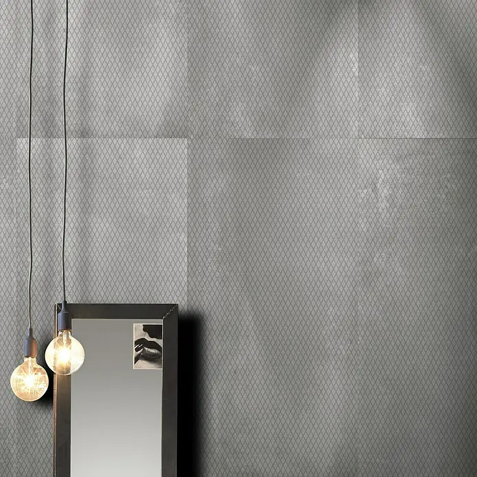 Feinsteinzeugfliese Metallo Zinco Dekor - 60 x 120 cm, Grau, Matt - Ein stilvolles Interieur mit grauer Rautenmuster-Tapete, beleuchtet von zwei Glühbirnen, die neben einem schwarzen Spiegel hängen.