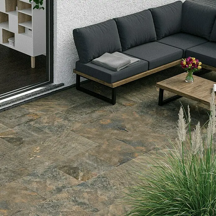 Marazzi Terrassenfliese Esterno 20T Rocking Grey - 60 x 60 x 2 cm, Grau/Braun, Matt - Außenaufnahme einer gefliesten Terrasse mit modernen Gartenmöbeln und üppigem Grün. Die Fliesen dominieren das Bild.
