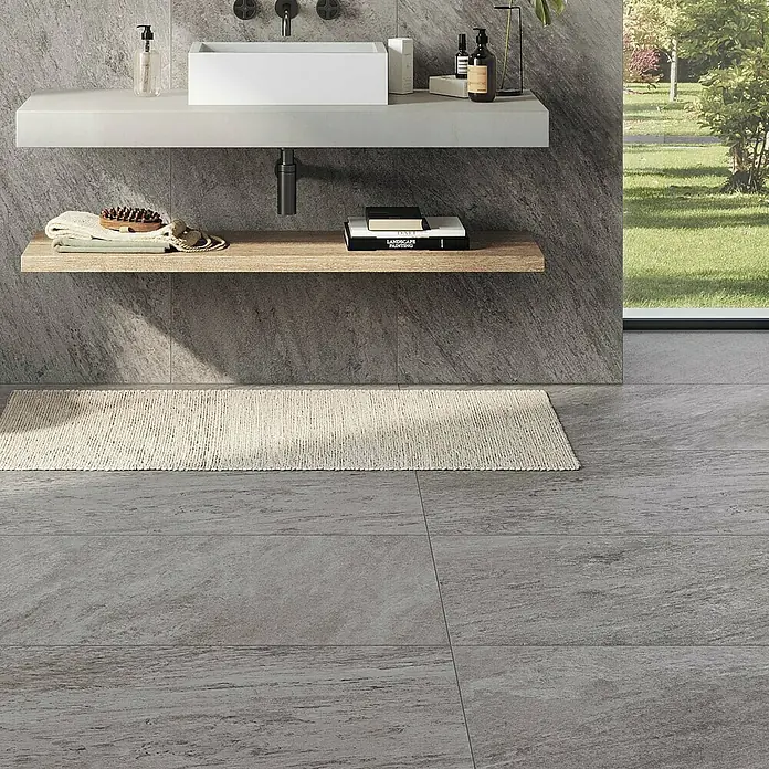 Atlas Concorde Solution Regent Feinsteinzeugfliese Silver - 60 x 120 cm, Silbergrau, Matt - Modernes Badezimmer-Interieur mit Waschbecken, Ablage und grauen Bodenfliesen. Der Bodenbelag sorgt für einen eleganten Touch.