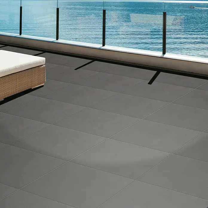 Terrassenfliese Garden Family Grey - 60 x 60 x 2 cm, Grau, Matt - Ein Außenbereich mit grauen Fliesen und Meerblick, der das elegante Design und die hochwertige Verarbeitung der Fliesen betont.