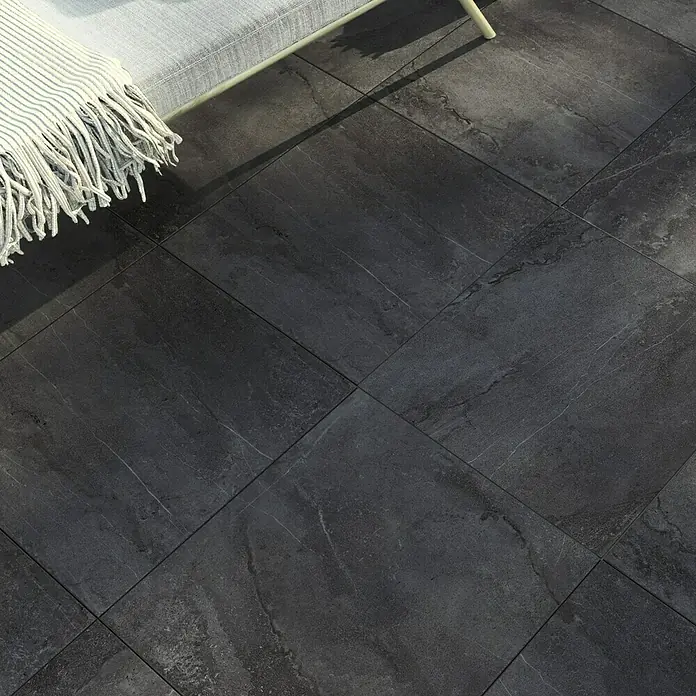 Terrassenfliese Aspen 2.0 - 60 x 60 x 2 cm, Anthrazit, Matt - Detailaufnahme von dunklen Bodenfliesen mit subtilen Marmorierungen, die eine elegante und moderne Atmosphäre schaffen.