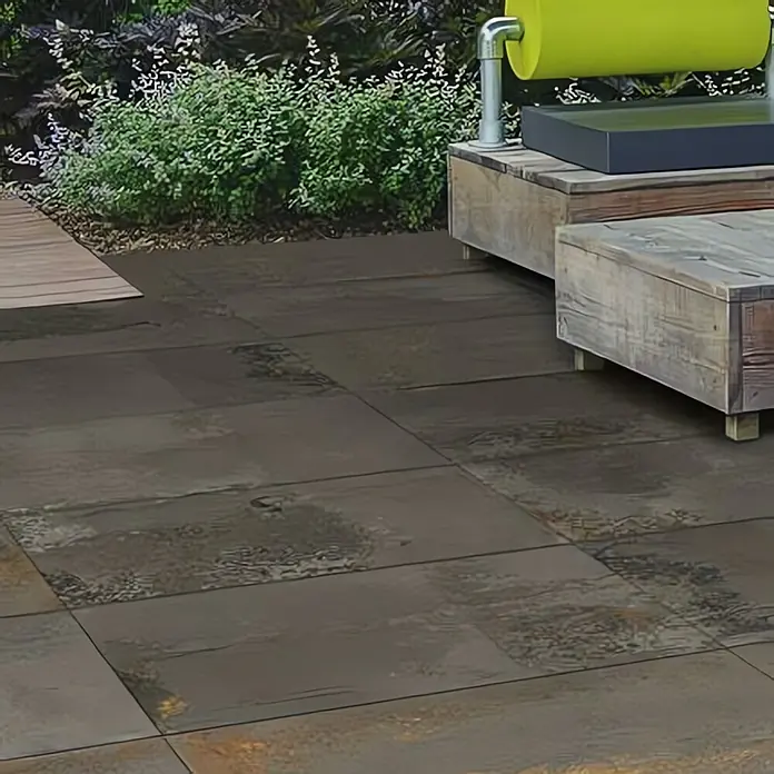 Terrassenfliese Metallic 2.0 - 60 x 120 x 2 cm, Anthrazit, Matt - Nahaufnahme von Bodenfliesen in einem Außenbereich, die eine rustikale und moderne Ästhetik vereinen. Die Fliesen ergänzen das natürliche Umfeld perfekt.