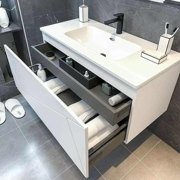 Disbain Conjunto de mueble de baño Lira - Ancho: 100 cm, Blanco, 3 pzs. - Lavabo moderno de baño con tocador blanco y accesorios negros. Los cajones están abiertos, revelando toallas y productos de cuidado personal.