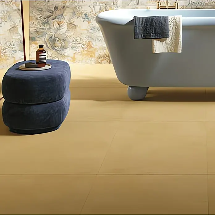 Feinsteinzeugfliese Mediterran Sun Gold - 120 x 120 cm, Ocker, Matt - Das Badezimmer verfügt über eine freistehende Badewanne, einen stilvollen Hocker und eine harmonische Farbpalette für ein entspannendes Ambiente.