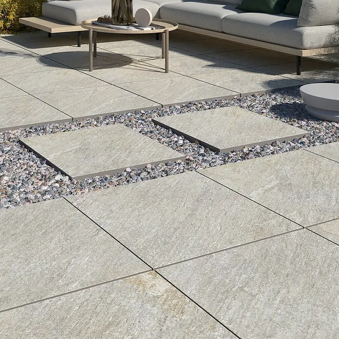 Terrassenfliese Piazza 2.0 - 59,7 x 59,7 x 2 cm, Sabbia, Matt - Quadratische Pflastersteine aus hellem Stein mit Kiesakzenten, die eine moderne und stilvolle Außenfläche schaffen.