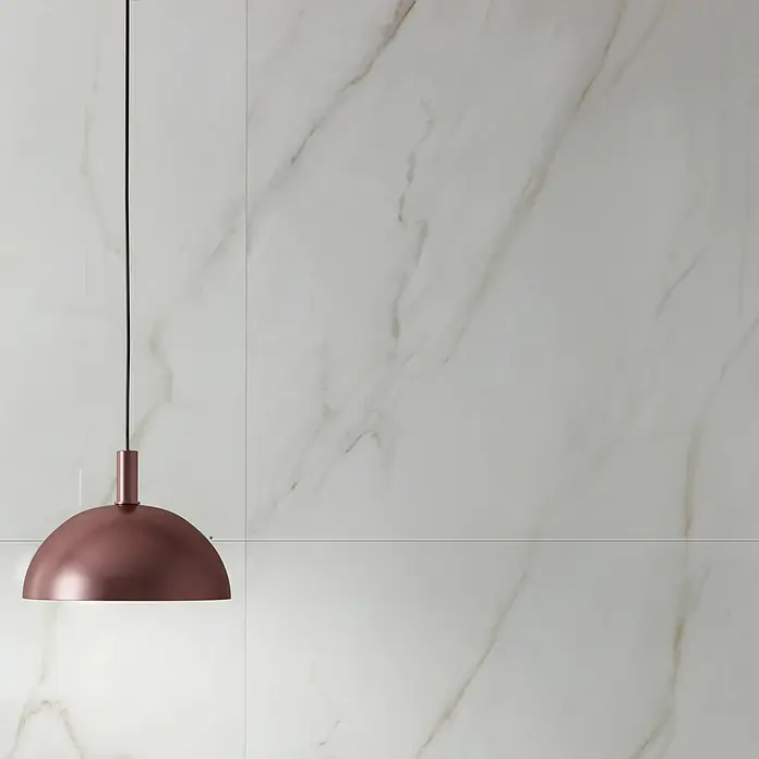 Feinsteinzeugfliese Calacatta Africa - 80 x 80 cm, Weiß, Glänzend - Elegante Kupfer-Hängelampe vor einer Marmorwand. Das moderne Designelement setzt einen stilvollen Akzent im Raum.