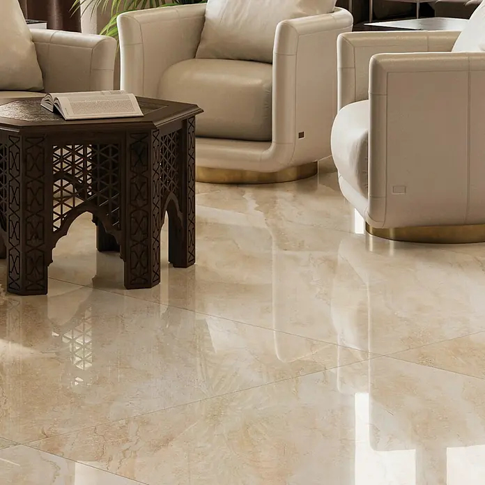 Feinsteinzeugfliese Breccia Diano - 80 x 80 cm, Beige, Glänzend - Nahaufnahme eines kunstvoll geschnitzten Beistelltisches mit Buch, ergänzt durch cremefarbene Sessel und einen glänzenden Boden.