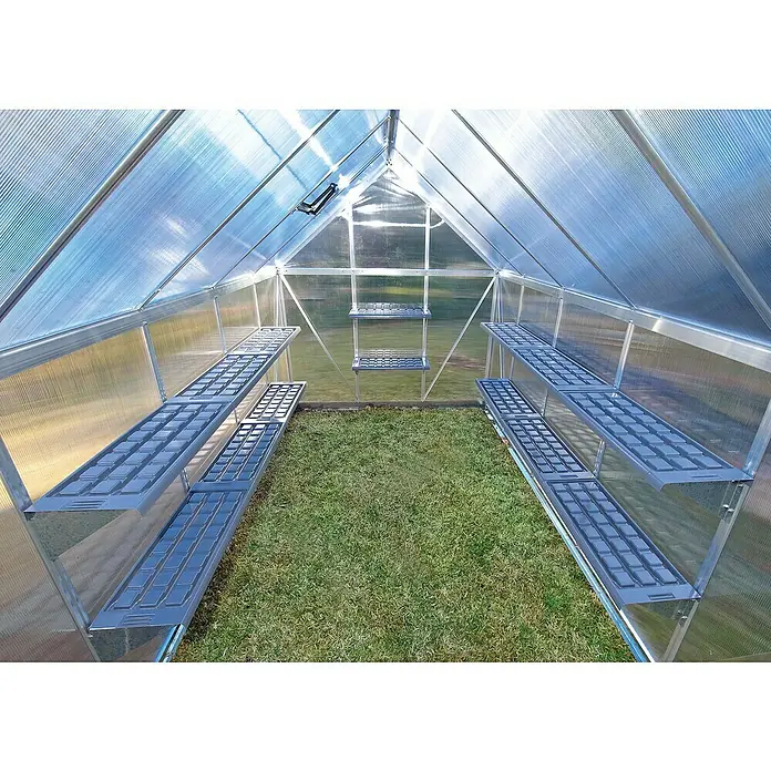 Palram – Canopia Estantería para invernadero - 125 x 26 cm, Acero - Interior de un invernadero con estanterías y suelo de césped, combinando diseño y funcionalidad para los amantes de las plantas.