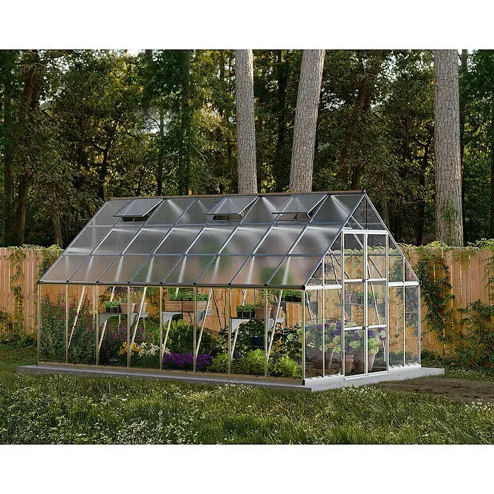 Palram – Canopia Invernadero Balance - Medidas ext. (An x Pr): 304 x 484 cm, 0,7 mm, Plateado - Un invernadero con plantas dentro, con ventanas en el techo, rodeado de árboles verdes y césped.