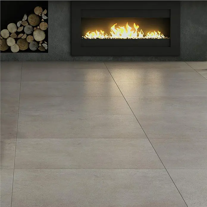 Art-Tec by Palazzo Feinsteinzeugfliese - 60 x 120 cm, Taupe, Glänzend - Das Bild zeigt einen Innenraum mit Fliesenboden, einem Kamin und dekorativem Holz. Die warmen Farben des Kamins kontrastieren mit den grauen Fliesen.