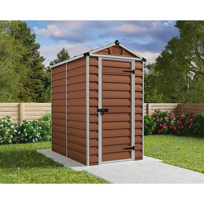 Palram – Canopia Caseta de jardín Skylight - Medidas ext. (An x Pr): 121 x 176 cm, Plástico, Ámbar - Un cobertizo de jardín de plástico marrón con marco gris sobre una superficie de hormigón en el jardín.
