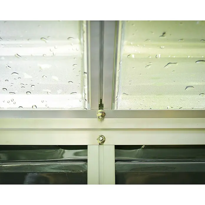 Palram – Canopia Caseta de jardín Skylight - Medidas ext. (An x Pr): 185 x 90 cm, Plástico, Antracita - Primer plano de una ventana con gotas de lluvia, que muestra los herrajes de la ventana y la textura del vidrio húmedo.