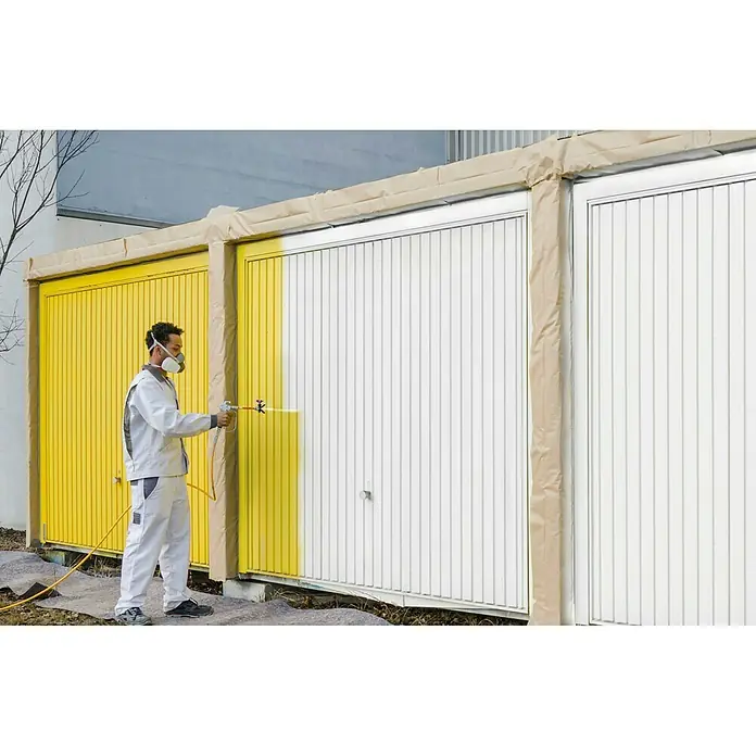Wagner High Efficiency Airless Farbsprühsystem ProSpray 20 - Leistungsaufnahme: 900 W, Förderleistung: 1,6 l/min - Ein Mann lackiert mit gelber Farbe eine Garagentür mit einem Farbsprühgerät, wobei er eine Maske und Schutzkleidung trägt, um sich zu schützen.