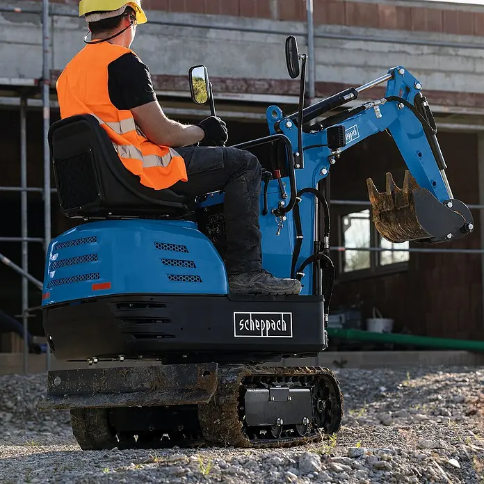 Scheppach Minibagger EXC815 - 6,3 kW, Auslegerschwenkbereich: -70 ° - 70 °, Benzin, Blau - Ein Bauarbeiter bedient einen blauen Scheppach Minibagger auf einer Baustelle. Ideal für kleine Aushubarbeiten.