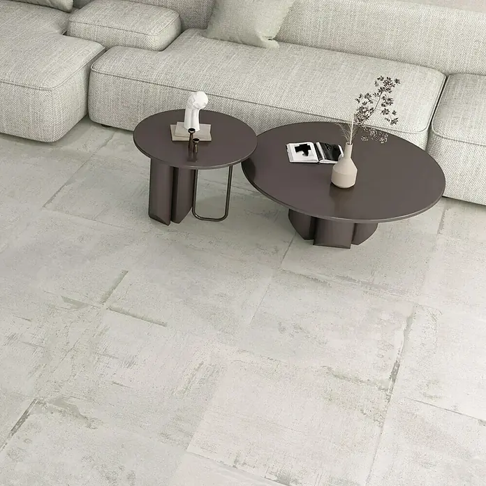 Feinsteinzeugfliese Bond White - 60 x 60 cm, Weiß, Matt - Eine moderne Wohnzimmereinrichtung mit einem hellen Sofa, zwei Couchtischen und einem hellen Teppich, der für eine gemütliche Atmosphäre sorgt.