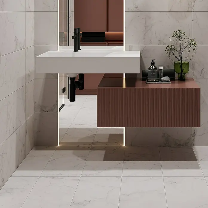 Feinsteinzeugfliese Ikarus - 29,8 x 59,8 cm, Weiß, Matt - Elegantes Badezimmer-Interieur mit weißem Waschbecken und rosafarbenem Unterschrank. Die Marmorfliesen verleihen dem Raum eine luxuriöse Note.