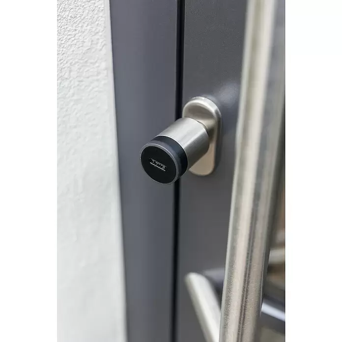 Abus Elektronisches Türschloss CYLOX™ One - Bedienung: Über App, Mit Schließung innen, Baulänge innen: 45 mm - 55 mm - Gebürsteter Metall-Türschließzylinder mit schwarzer ABUS-Kappe neben passendem Türgriff.
