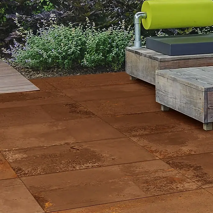 Terrassenfliese Metallic 2.0 - 100 x 100 x 2 cm, Kupfer, Matt - Rostfarbene Bodenfliesen aus Metall mit unregelmäßiger Textur, die im Außenbereich verlegt sind und einen industriellen Stil erzeugen.