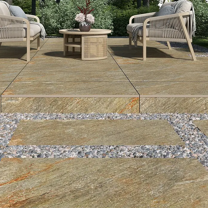 Terrassenfliese Piazza 2.0 - 59,7 x 119,7 x 2 cm, Multicolor, Matt - Ein Außenbereich mit Natursteinplatten in warmen Farbtönen, ergänzt durch Kies und Sitzmöbel.