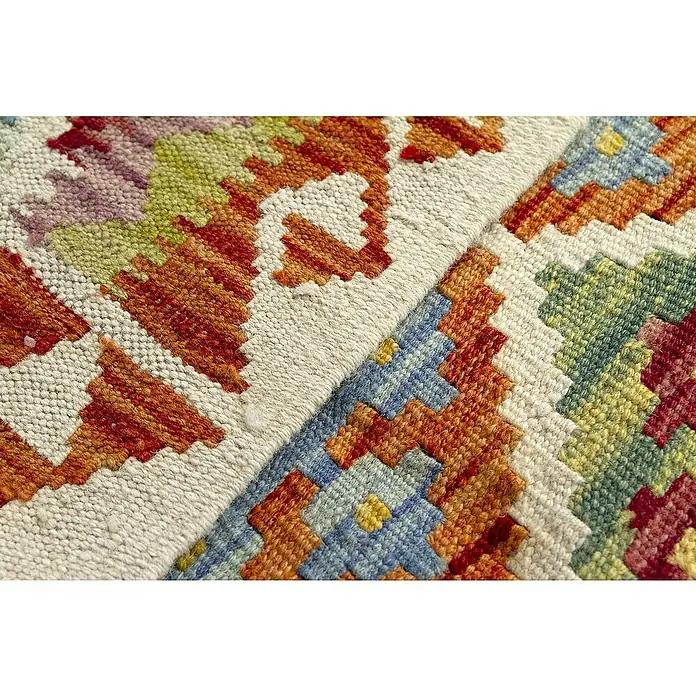 Alfombra de pelo corto Kilim Herat - Multicolor, 180 x 120 cm, 100% lana - Primer plano de un textil tejido vibrante, con patrones geométricos y textura rústica, ideal para detalles de decoración.