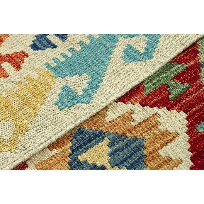 Alfombra de pelo corto Kilim Herat - Multicolor, 240 x 170 cm, 100% lana - Primer plano de una alfombra colorida con patrones geométricos y diversos tonos, creando un ambiente cálido y acogedor.