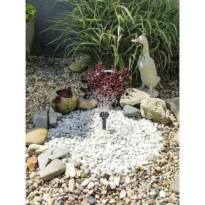 Ubbink Wasserspielpumpe ProLine 3000 Eco - Fördermenge pro Std.: 2.510 l - Dekorative Gartenbrunnen mit weißem Kiesbett, umgeben von Steinen und Pflanzen. Eine Entenstatue verleiht dem Ambiente eine skurrile Note.