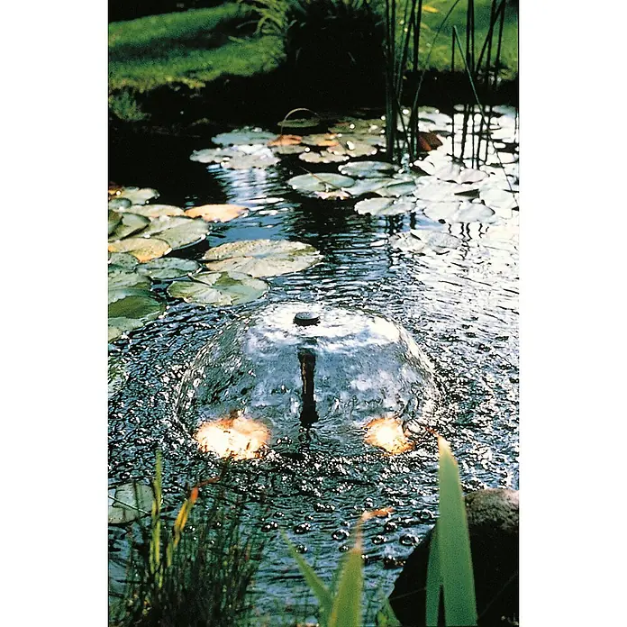 Ubbink Wasserspielpumpe ProLine 700 Eco - Fördermenge pro Std.: 700 l - Eine Teichfontäne sprudelt in einem üppigen Gartenteich, umgeben von Seerosen und grünen Pflanzen. Das Wasser plätschert beruhigend.