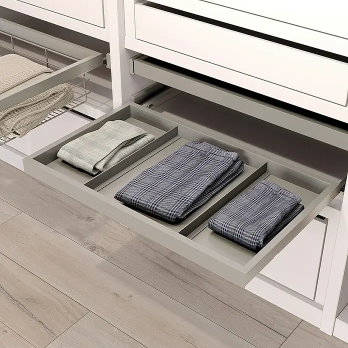 Emuca Ablagefach Hack - Breitenverstellung: 560 mm - 594 mm, Grau - Image einer grauen Ausziehschublade mit Fächern für ordentlich gefaltete Kleidung in einem weißen Kleiderschrank.
